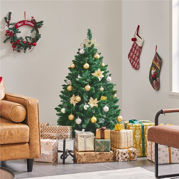 Dekorierter Weihnachtsbaum mit Geschenken, Weihnachtsstern, Christbaumkugeln und Weihnachtsdekoration in einem Zimmer.