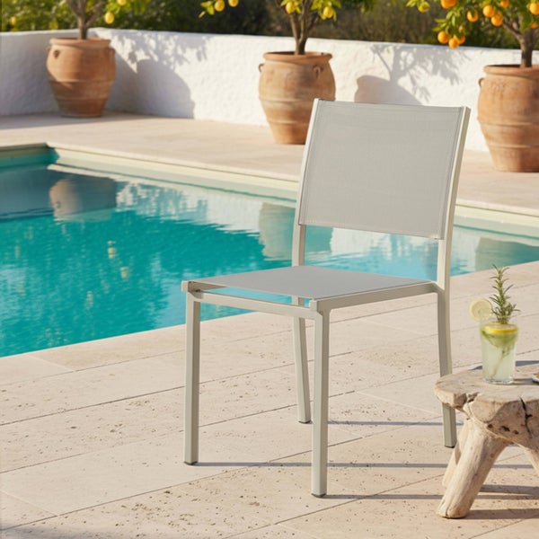 Moderner Gartenstuhl aus Metall mit Textilbespannung auf einer Steinterrasse neben einem Swimmingpool.