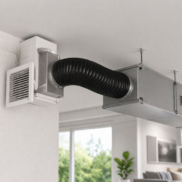 Installierte Wohnraumlüftung mit Wandgitter, schwarzem Flexschlauch und einem an der Decke montierten Lüftungskanal aus Metall.