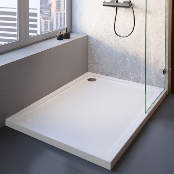 Modernes Badezimmer mit rechteckiger weißer Duschwanne mit Struktur, Glasduschwand und Marmorwand mit dunkler Duscharmatur.
