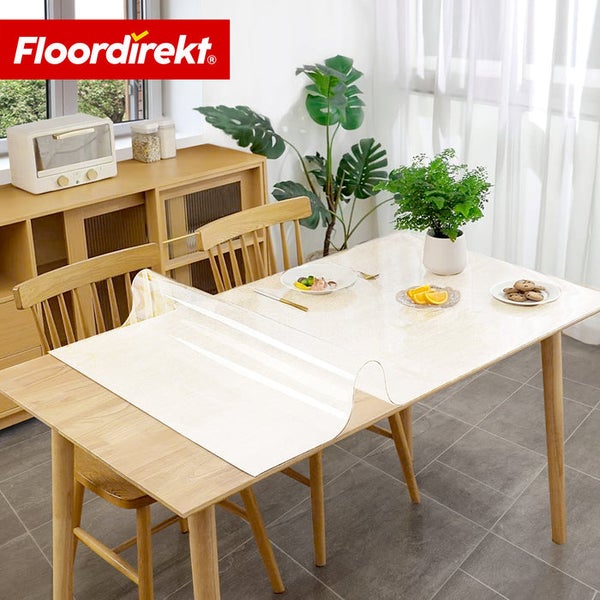 Esstisch mit transparenter Tischdecke und Alltagsgegenständen