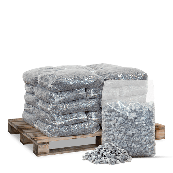 Mehrere Säcke grauer Ziersplitt auf einer Holzpalette gestapelt mit einem einzelnen Sack und losem Splitt davor.