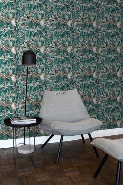 Szene mit gemusterter Tapete, Stehlampe, Beistelltisch und Sessel.