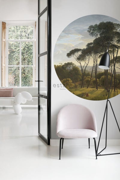 Szene eines hellen Zimmers mit einem Wandbild, einem Sessel und einer Stehlampe.