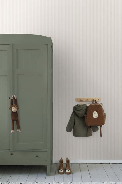 Kinderzimmer-Einrichtung mit gestreifter Tapete, einem grünen Kleiderschrank aus Holz und einer Wandhakenleiste.