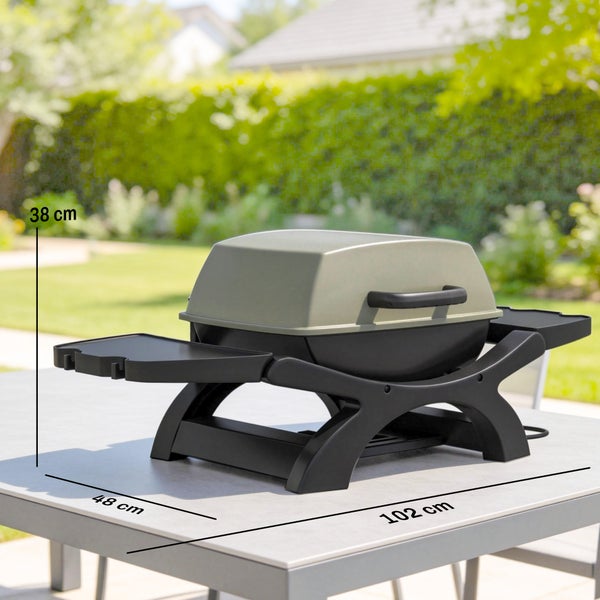 Tischgrill auf einem Gartentisch mit den Maßen: Höhe 38 Zentimeter, Breite 102 Zentimeter, Tiefe 48 Zentimeter.