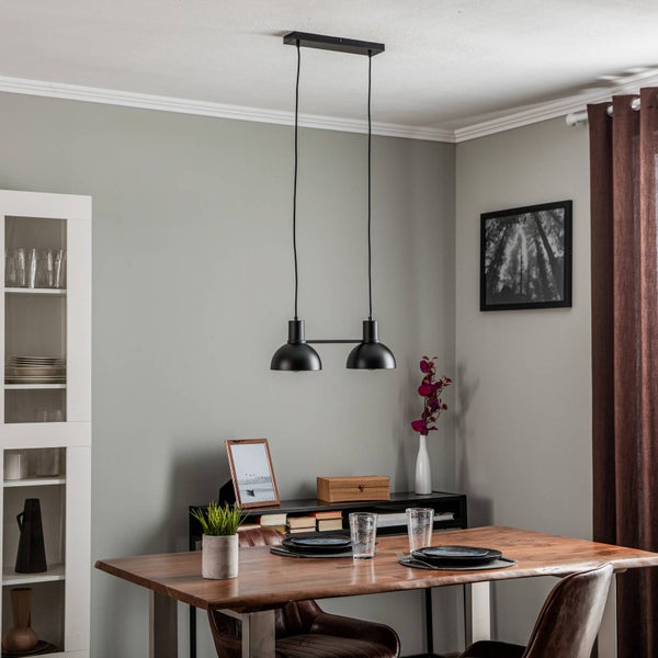Esstisch-Szene mit schwarzer Hängelampe über Holztisch