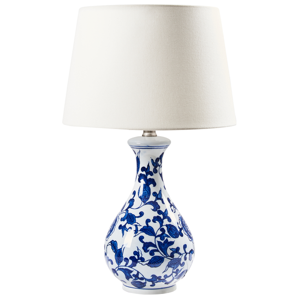 Tischleuchte mit weißem Lampenschirm und blau-weißem Blumendekor auf dem Lampenfuß.