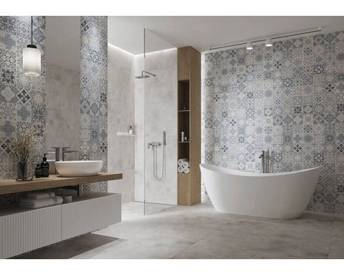 Helles Badezimmer mit freistehender Badewanne, begehbarer Dusche und Wandfliesen in Patchwork-Optik.