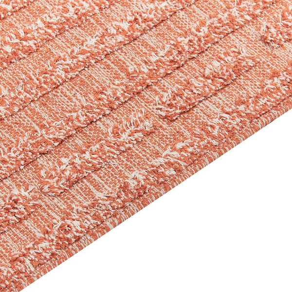 Nahaufnahme eines gewebten Teppichs in Terracotta und Weiß mit Streifenmuster und strukturierter Oberfläche.