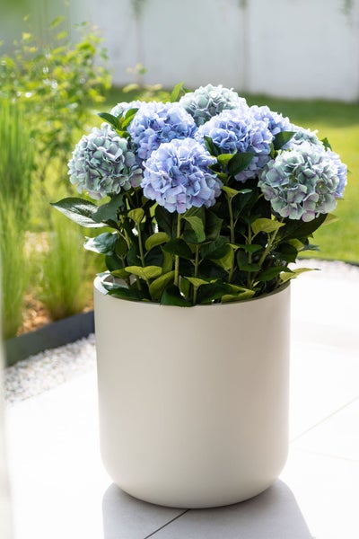 Künstliche Hortensie mit Blüten in einem runden Übertopf zur Dekoration im Innen- und Außenbereich.