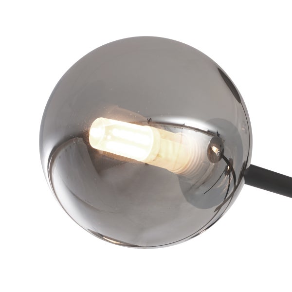 Nahaufnahme eines kugelförmigen Lampenschirms aus Rauchglas mit leuchtendem Leuchtmittel und schwarzem Haltearm.