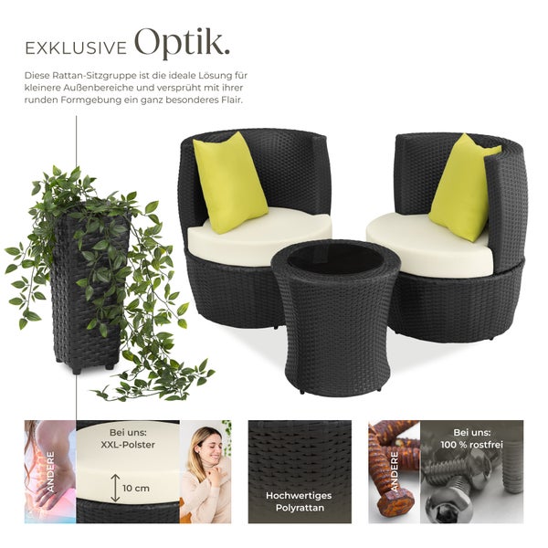 Rattansitzgruppe mit zwei Sesseln, einem Tisch und einer Topfpflanze