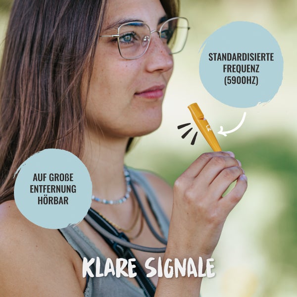 Frau mit Brille hält Signalpfeife