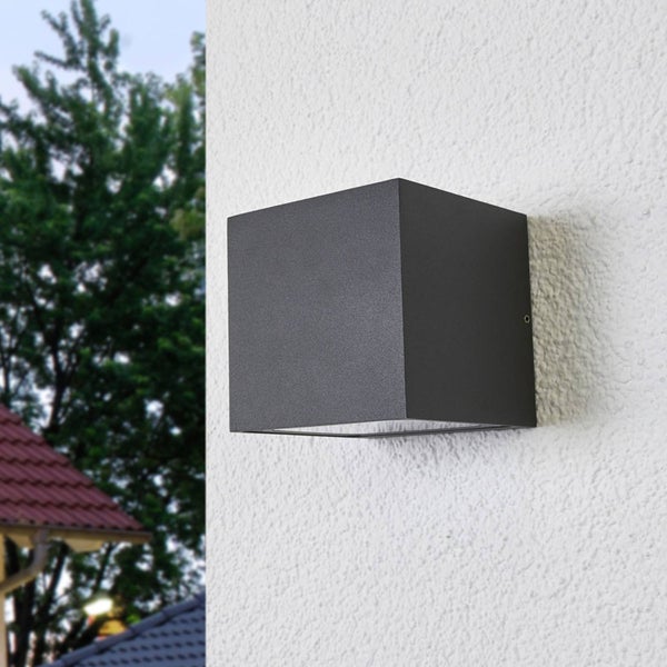 Moderne, würfelförmige Außenwandleuchte in Anthrazit, montiert an einer verputzten Außenwand.