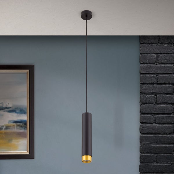 Moderne zylindrische Pendelleuchte in minimalistischem Design zur Deckenmontage vor einer Wand mit Ziegelsteinelementen