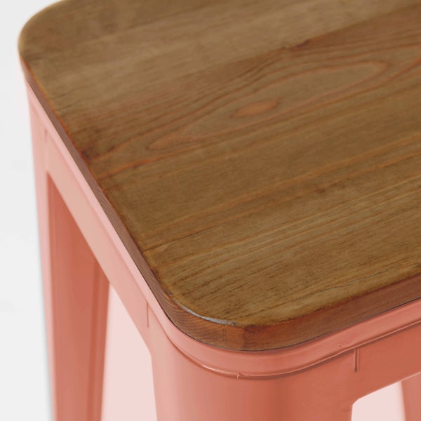 Detailansicht eines korallenfarbenen Hockers mit Holzsitzfläche und Metallgestell.