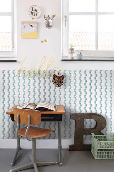 Kinderzimmer mit Schreibtisch, Stuhl und dekorativer Wandtapete mit Wellenmuster