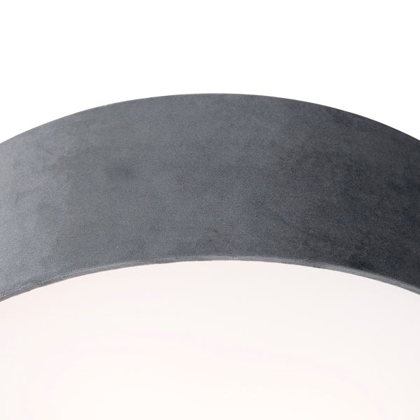 Detailansicht eines runden Lampenschirms mit grauer Textiloberfläche aus Samt.