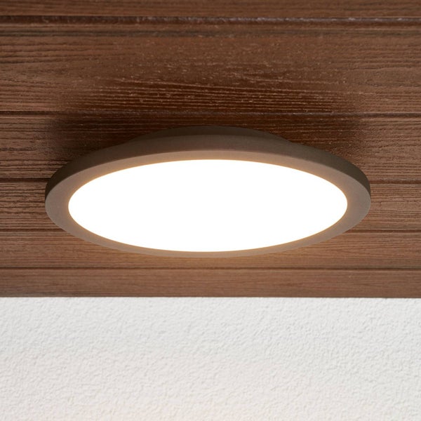 Runde LED-Deckenleuchte mit warmweißem Licht, montiert an einer Paneeldecke aus dunklem Holz.