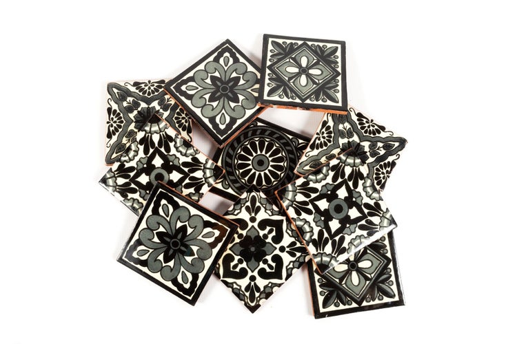 Stapel von quadratischen Fliesen mit floralen Mustern