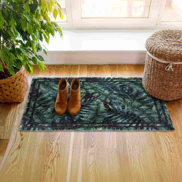 Fußmatte mit Pflanzenmuster, Schuhe und Pflanze im Topf vor einem Fenster.