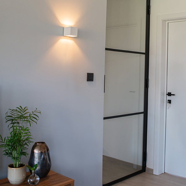 Flur mit Wandleuchte, Zimmerpflanzen und Glastür