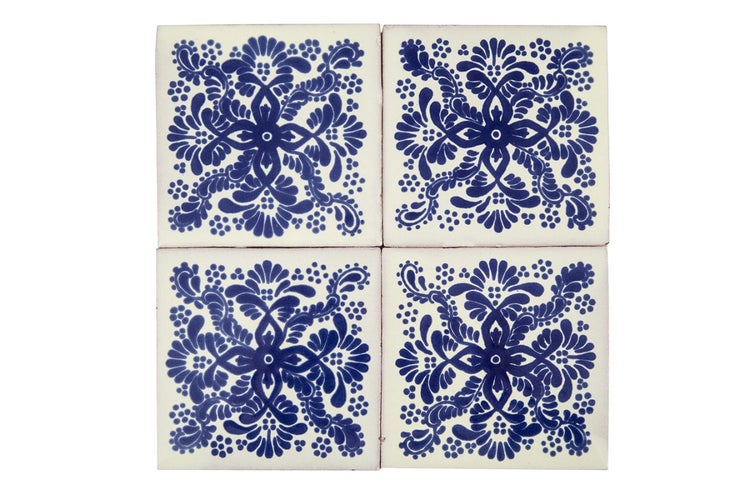 Vier quadratische Fliesen mit blauem Blumenmuster