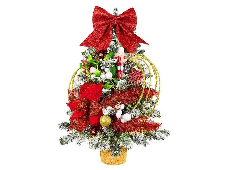 Künstlicher Weihnachtsbaum mit festlicher Dekoration wie Schleife, Nussknacker und Kugeln in einem Jutesack.