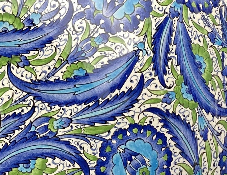 Detailansicht eines Keramikmusters mit floralen Motiven in Blau und Grün