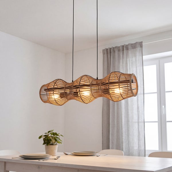 Dreiflammige Pendelleuchte mit gewelltem Schirm aus geflochtenem Holz über einem hell gedeckten Esstisch in einem hellen, organisierten Zimmer.
