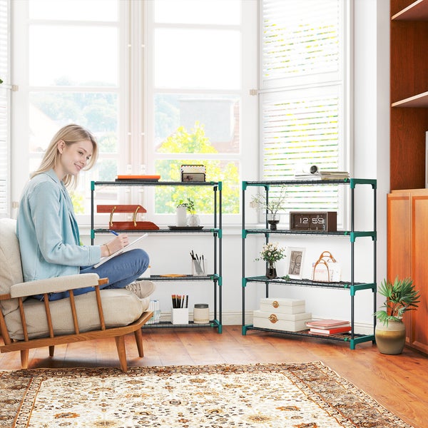 Zwei schwarze Metallregale mit grünen Verbindern in einem hellen Zimmer mit Sessel, Fenster und gemustertem Teppich.