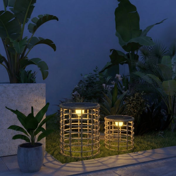 Zwei zylindrische Solarleuchten mit Seilumflechtung in verschiedenen Größen, warmes Licht in einer nächtlichen Gartenlandschaft mit Pflanzen.