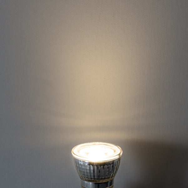 Leuchtendes GU10 LED-Leuchtmittel mit warmweißem Lichtstrahl und facettiertem Reflektor.