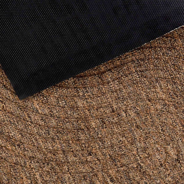 Detailaufnahme einer braunen Fußmatte mit strukturierter Oberfläche und schwarzer rutschhemmender Rückseite.