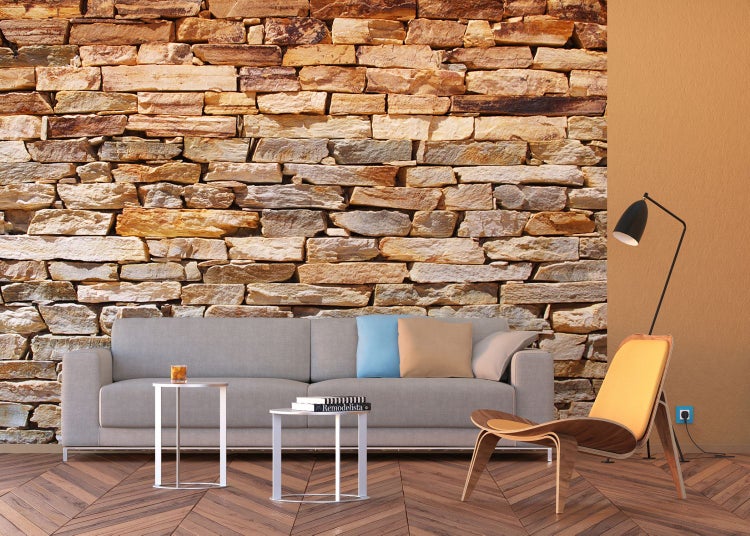 Wohnzimmer mit Steinwandtapete, Sofa, Tischen, Sessel und Stehlampe