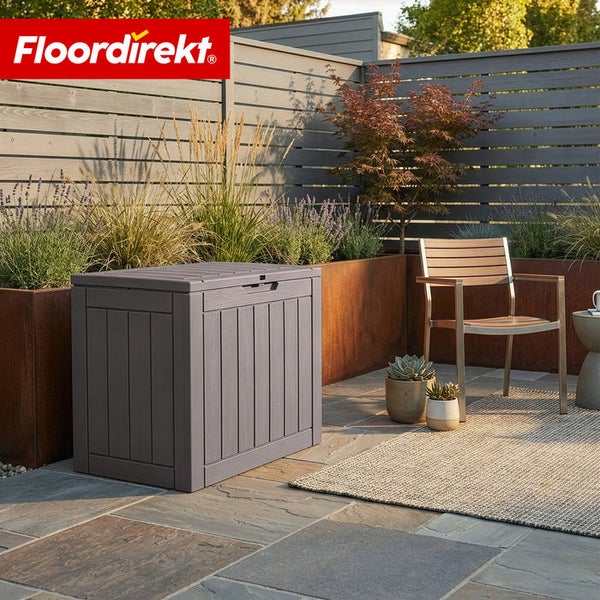 Gartenszene mit einer grauen Aufbewahrungsbox, einer Holzbank und Pflanzenkübeln vor einem Holzzaun