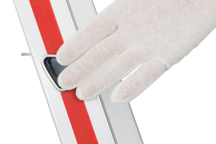 Detailaufnahme einer Hand mit Handschuh, die eine Leiter bedient