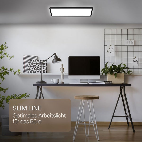 Flaches, rechteckiges LED-Panel an der Decke eines hellen, modernen Homeoffice mit Schreibtisch, Monitor und Zimmerpflanzen.
