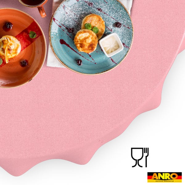 Einfarbige rosa Tischdecke mit feiner Webstruktur, eingedeckt mit Frühstückstellern, lebensmittelecht, ANRO Logo.
