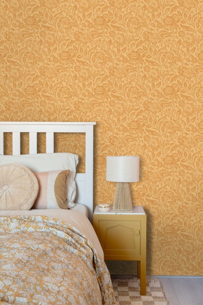 Schlafzimmer mit Bett, Nachttischlampe und gemusterter Tapete