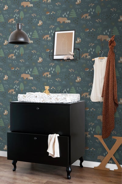 Dekoriertes Kinderzimmer mit Wickelkommode und Waldtapete mit Tiermotiven
