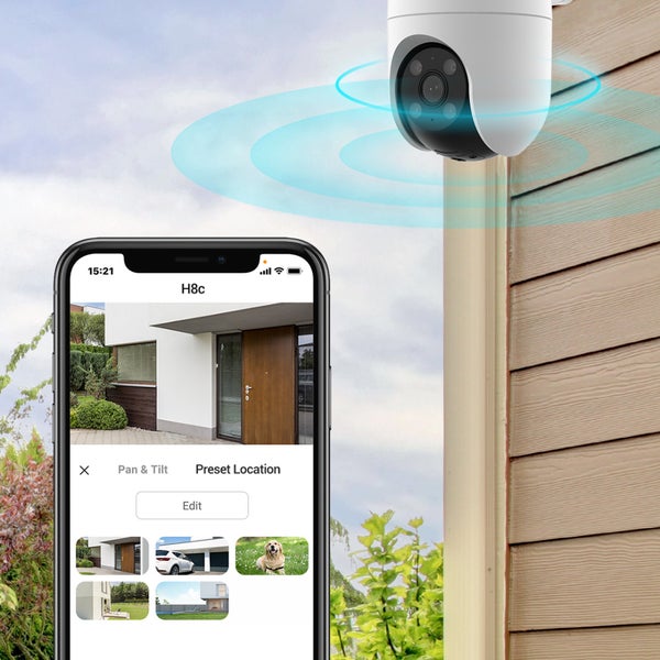 Smarte Außen-Überwachungskamera an einer Hauswand mit Smartphone-App zur Steuerung und Anzeige von Live-Bildern verschiedener Standorte.