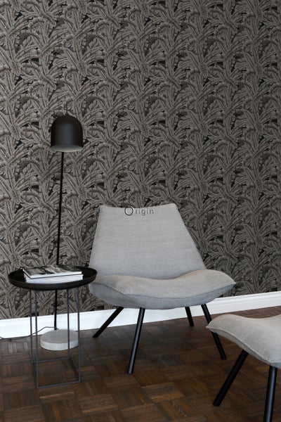 Wohnraum mit grauer Blättertapete, Sessel, Beistelltisch und Stehlampe