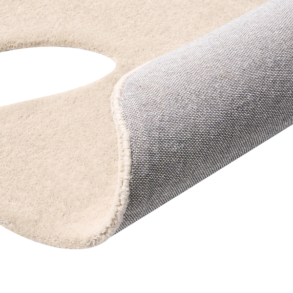 Beige Badematte mit WC Ausschnitt, Detailansicht der weichen Oberfläche und der strukturierten Unterseite.