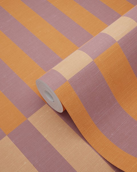 Vliestapete als Rolle mit breiten Blockstreifen in Orange, Mauve und Beige sowie feiner Oberflächenstruktur.