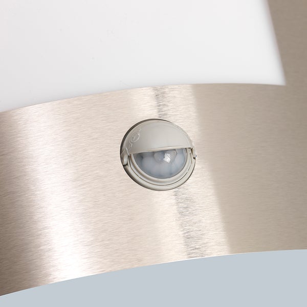 Nahaufnahme eines Bewegungsmelders an einer Leuchte aus gebürstetem Edelstahl.