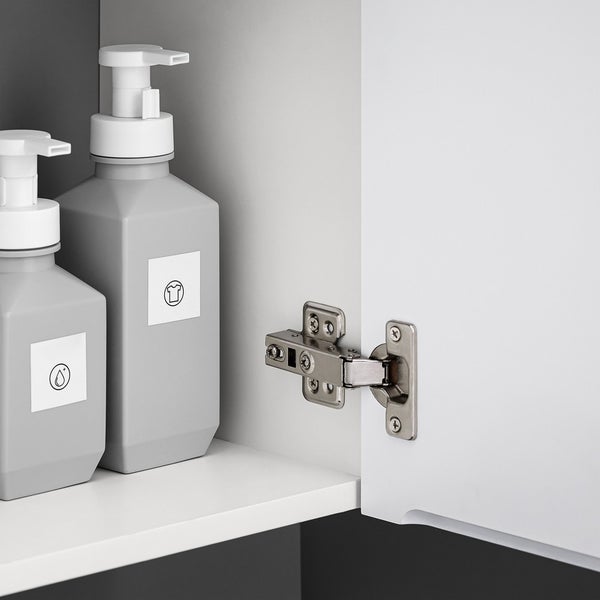 Zwei graue Seifenspender mit Symbolen im Badezimmerschrank