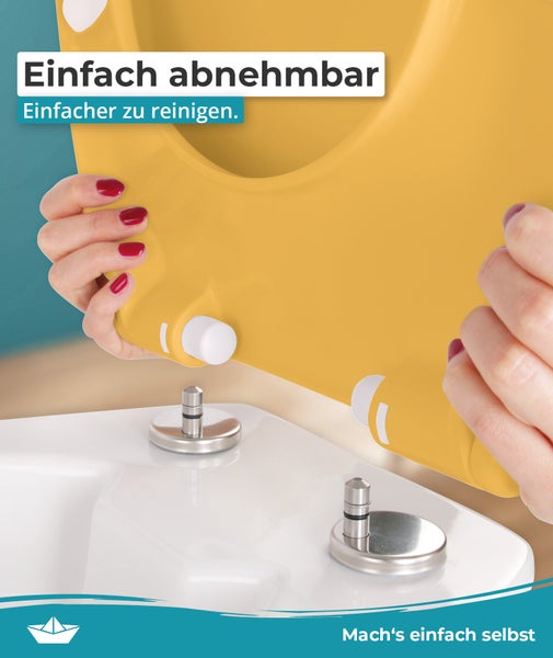 Abnehmbarer gelber WC-Sitz zur einfachen Reinigung, Montage an Metallbolzen der weißen Keramik-Toilette. Hornbach Logo.