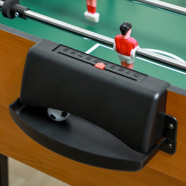 Nahaufnahme eines Tischfußball-Tisches mit manuellem Torzähler, Ballausgabe inklusive Ball und Spielfigur auf dem Spielfeld.